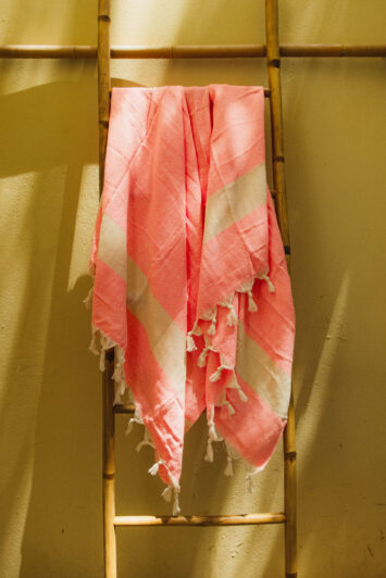 Ροζ πετσέτα hammam διπλωμένη διακοσμητικά πάνω σε ξύλινη σκάλα