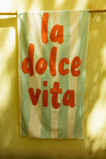 Βαμβακερή πετσέτα θαλάσσης με ρίγες και τύπωμα "La Dolce Vita". Απαλή, απορροφητική και statement για το καλοκαίρι!