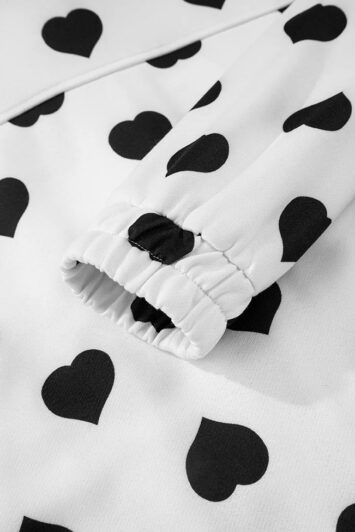 μανίκι λευκής ζακέτας με μαύρες καρδιές και λάστιχο